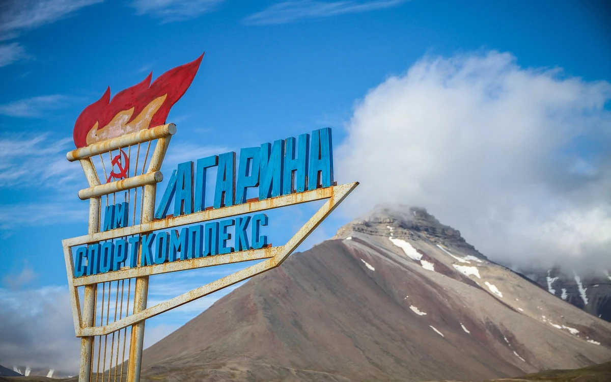 The empty apartment blocks and square of Pyramiden under a pale summer sky