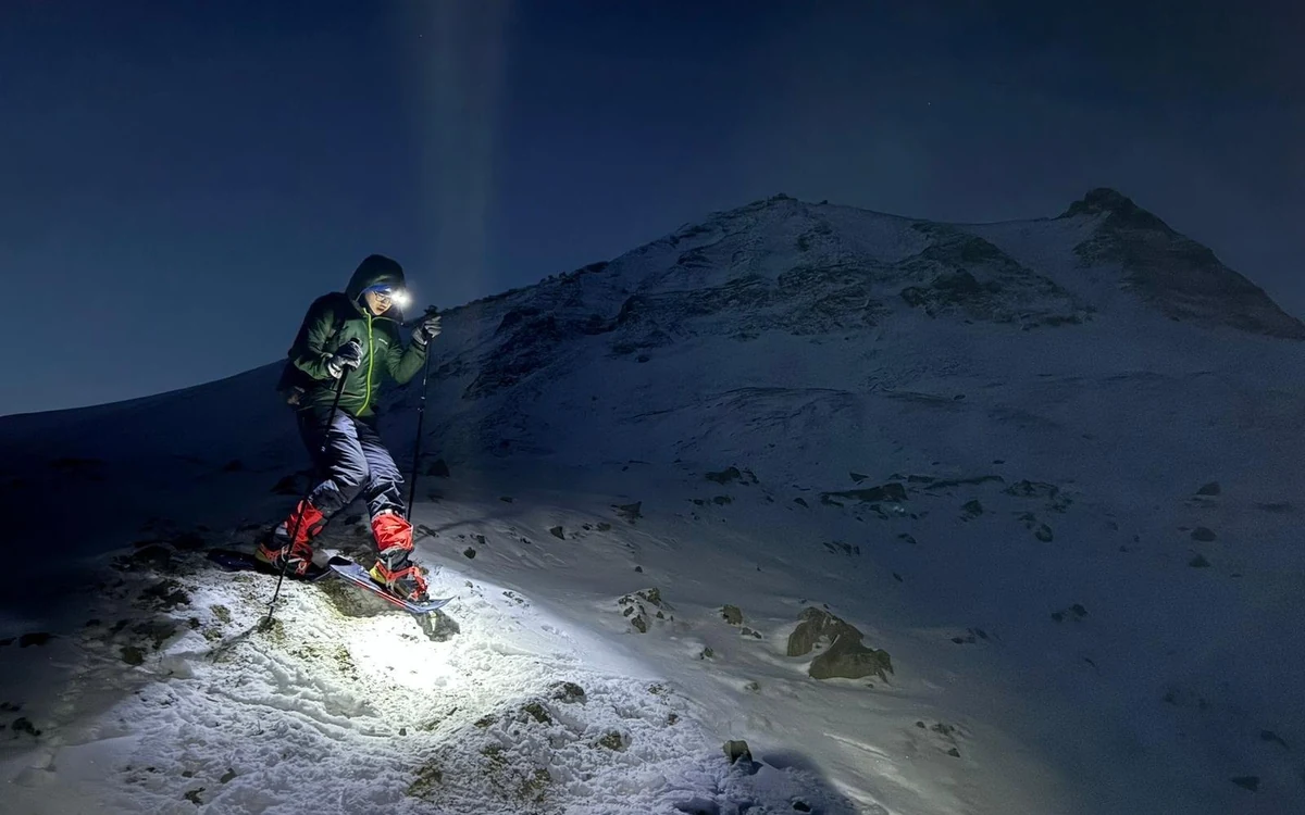 Walkers on snowshoes climbing a snow slope towards a glacier front on Svalbard